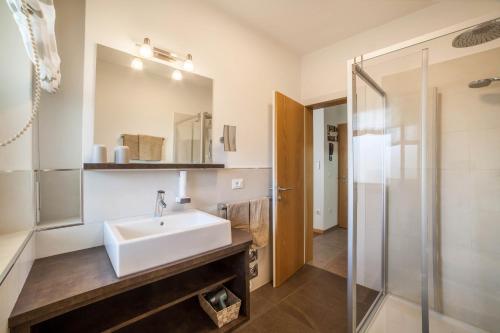a bathroom with a sink and a shower at Schnitzer Ferienwohnung Löwenzahn in Rablà