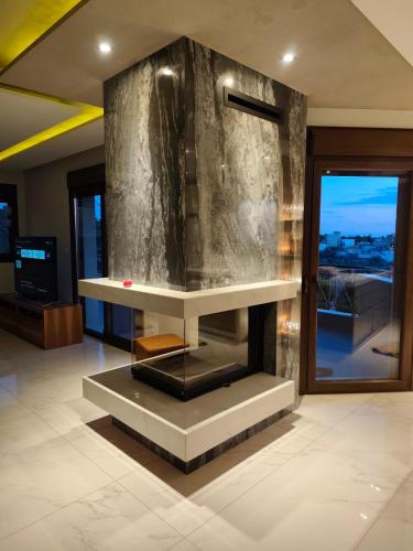a lobby with a fireplace in a building at Moumis Luxury Apartment in Limenaria