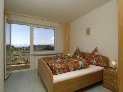 a bedroom with a bed and a large window at Landhaus Erben in Wasserburg