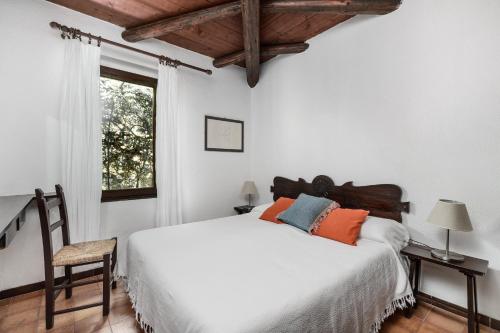 a bedroom with a white bed and a window at Villa Romana in Costa Rei