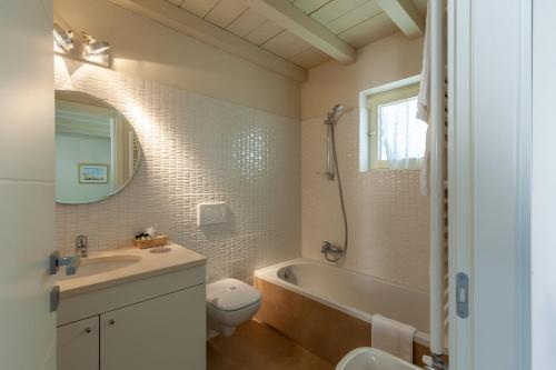 a bathroom with a tub and a toilet and a sink at Appartamento Bacco in Lido di Camaiore