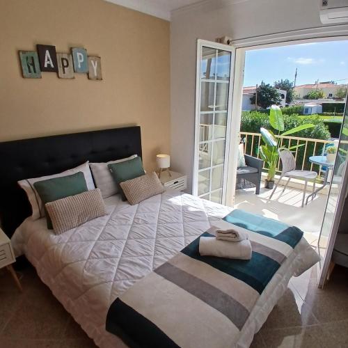 a bedroom with a large bed and a balcony at Villa Martinique in Albufeira