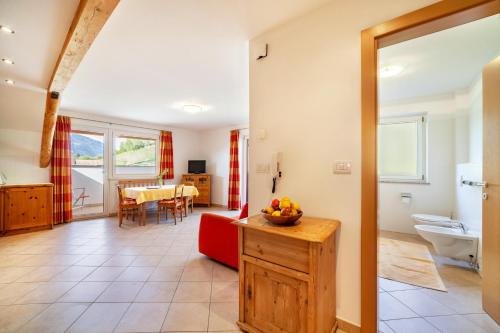a living room with a red couch and a table at Gasserhof Ferienwohnung Jonagold in Caines