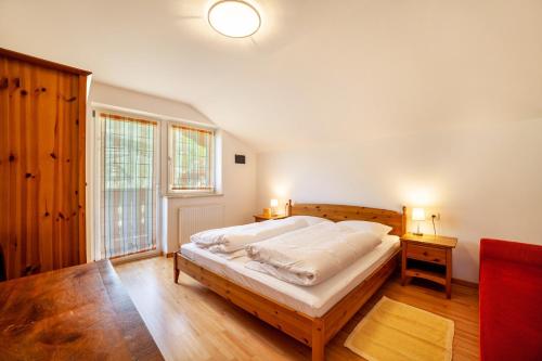 a bedroom with a bed with white sheets and a window at Gasserhof Ferienwohnung Jonagold in Caines