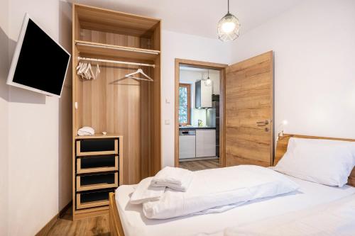 a bedroom with a bed and a tv and a kitchen at Goodlife Top 1 in Saalbach-Hinterglemm