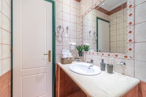 a bathroom with a sink and a mirror at Spyridoula Studio 10 in Paleokastritsa