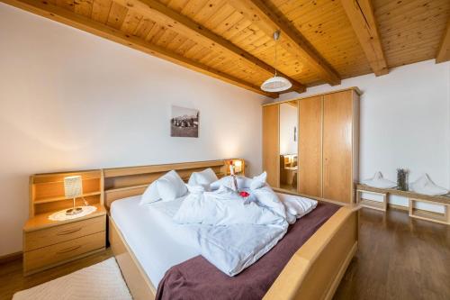 a bedroom with a bed with white sheets and pillows at Eichernhof Apartment Marillenblüte in Verano
