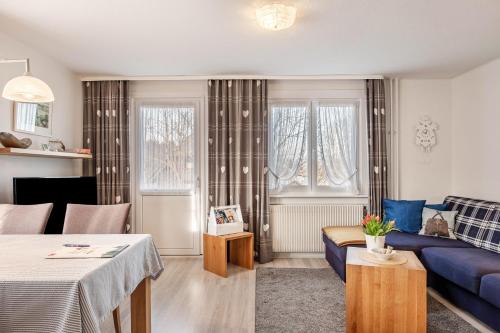 a living room with a blue couch and a table at Ferienwohnung Dachtler in Hinterzarten