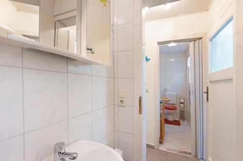 a white bathroom with a sink and a mirror at Ferienbungalow 2 in Boitzenburg in Boitzenburg