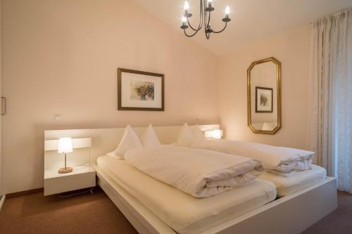 a bedroom with a large white bed with a mirror at Pfirsichblüte in Lindau