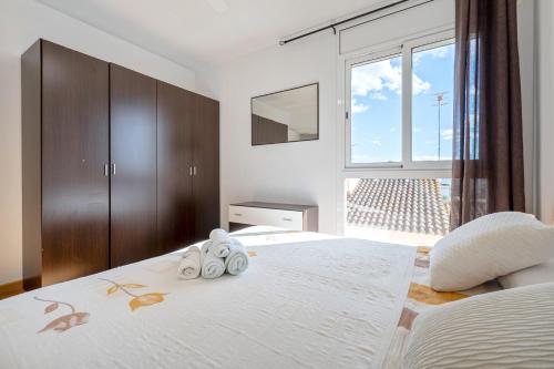 a bedroom with a large bed with two towels on it at Dorada Apartment Sol in Calafell