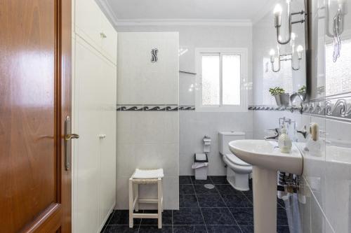 a white bathroom with a sink and a toilet at Villa Eden Nerja in Nerja