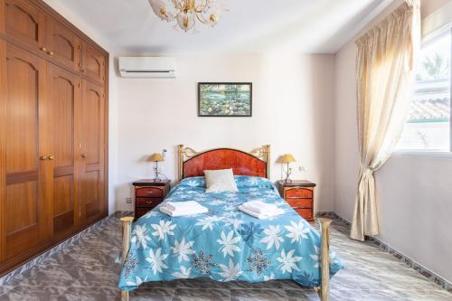 a bedroom with a bed with a blue blanket at Villa Eden Nerja in Nerja