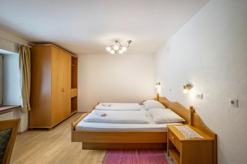 a small bedroom with a bed and a cabinet at Gartnerhof Apt Glücksklee in Colle Isarco