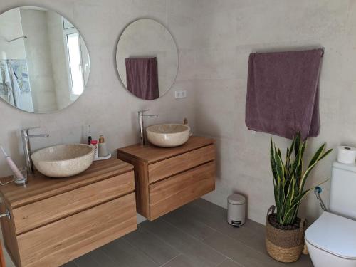 a bathroom with two sinks and a mirror at Casa Luzia in Miami Platja