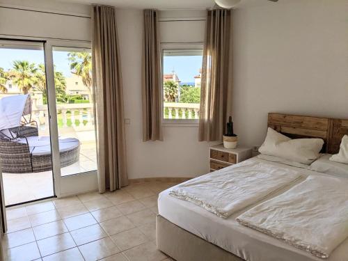 a bedroom with a bed and a balcony at Casa Luzia in Miami Platja