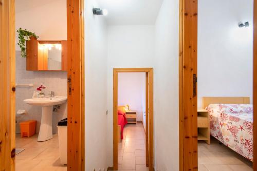 a bathroom with a sink and a mirror in a room at Fantastico quadrilocale vista mare in Trinità d'Agultu e Vignola