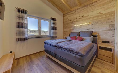 a bedroom with a bed in a room with a window at Luxus Chalet Landhaus Rachelblick in Eppenschlag