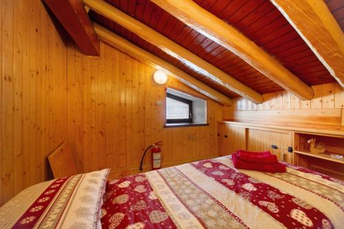 a bedroom with a bed in a wooden room at Petite Maison des Alpes in Morgex