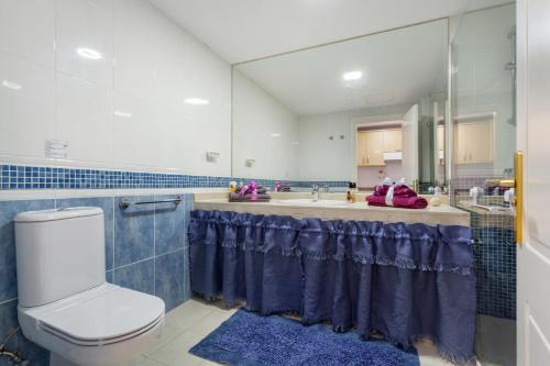 a bathroom with a sink and a toilet and a mirror at Oasis Bahia Fronte Piscine in Corralejo