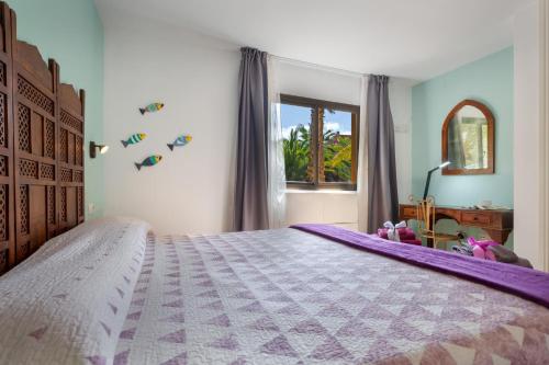 a bedroom with a large bed and a window at Oasis Bahia Fronte Piscine in Corralejo