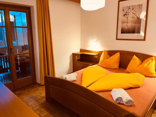 a bedroom with a yellow bed with yellow pillows at Residence Zirmer Wohnung Erde in Castelrotto
