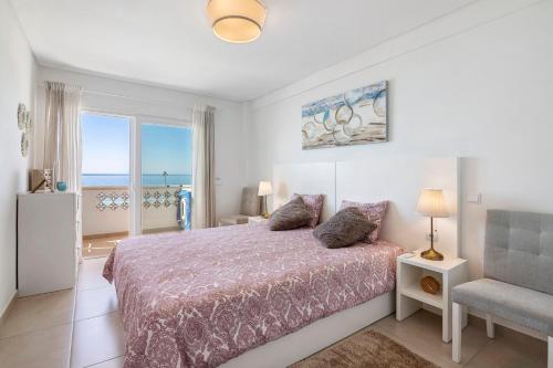 a bedroom with a bed with a view of the ocean at Paraná in Quarteira
