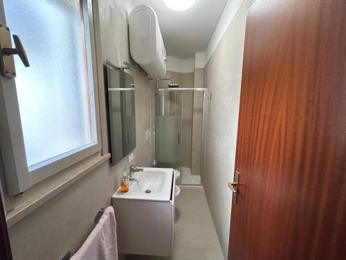 a small bathroom with a sink and a shower at Villaggio Olimpia in Bibione