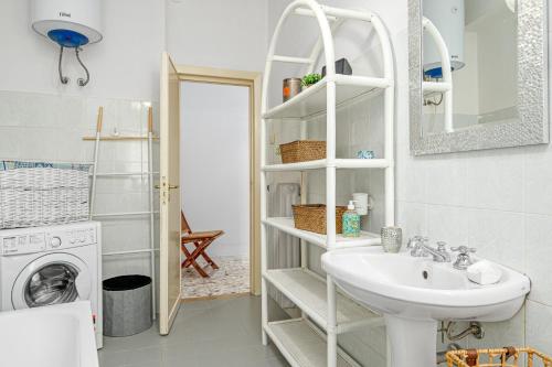 a bathroom with a sink and a washing machine at Appartamento del corso in Olbia