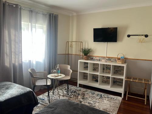 a room with a bed and a table and a tv at Quinta da Vigia in Angra do Heroísmo