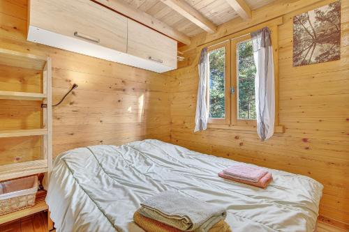 a bedroom with a bed in a wooden cabin at Chalet Le Mazet in Les Prats