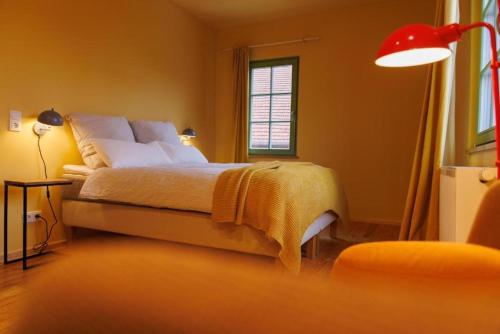 a bedroom with a bed and a red lamp at Ferienhaus Monteverde in Meddersheim