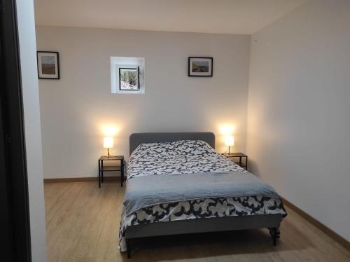 a bedroom with a bed and two lamps on two tables at Casa da Mina in Mina do Bugalho