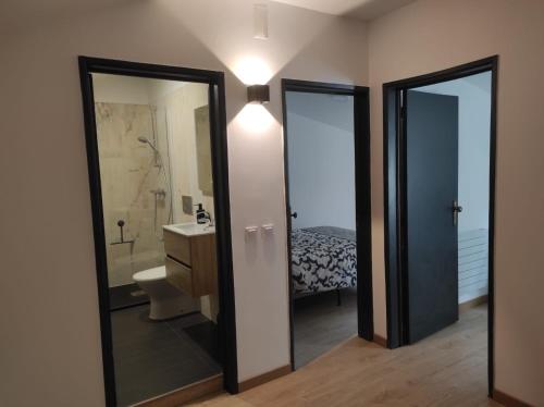 a bathroom with a sink and a toilet and a mirror at Casa da Mina in Mina do Bugalho