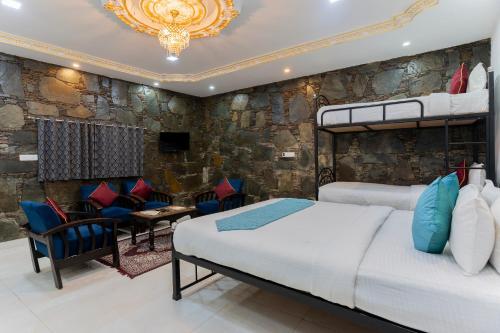 a bedroom with two beds and a stone wall at Emperor Palace Heritage Villa Udaipur in Udaipur