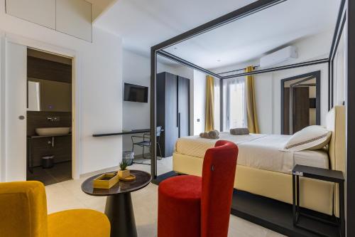 a hotel room with a bed and a table and chairs at Gatto Matto in Brolo