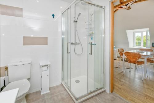 a shower in a bathroom with a toilet and a table at Martin - Appartement Le Croisic in Le Croisic