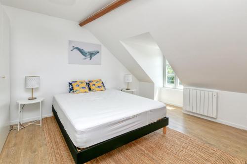 a white bedroom with a bed and a window at Martin - Appartement Le Croisic in Le Croisic