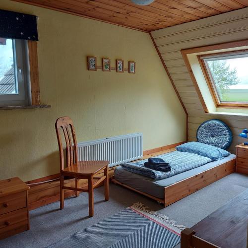 a room with a bed and a chair and a window at Ferienhaus Hadler in Kaiser Wilhelm Koog