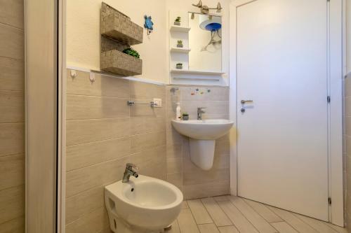a bathroom with a sink and a toilet at Baia delle mimose vista mare in Badesi