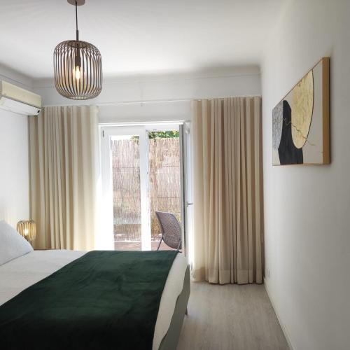 a bedroom with a bed and a sliding glass door at Casa dos Avós in Cascais