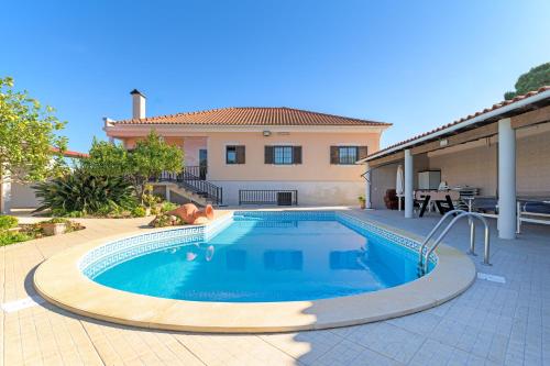 a swimming pool in front of a house at Beautiful Deluxe Villa 4 Bedroom in Aldeia de Brescos