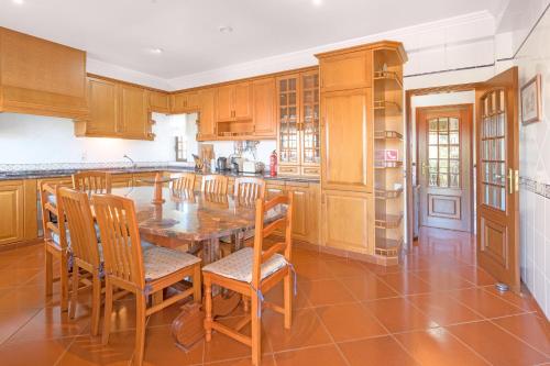 a kitchen with wooden cabinets and a table and chairs at Beautiful Deluxe Villa 4 Bedroom in Aldeia de Brescos
