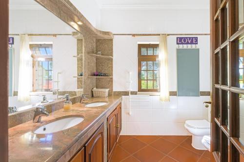 a bathroom with two sinks and a toilet at Beautiful Deluxe Villa 4 Bedroom in Aldeia de Brescos