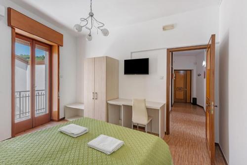 a bedroom with a bed and a desk and a television at Appartamento il Sentiero degli Dei in Agerola