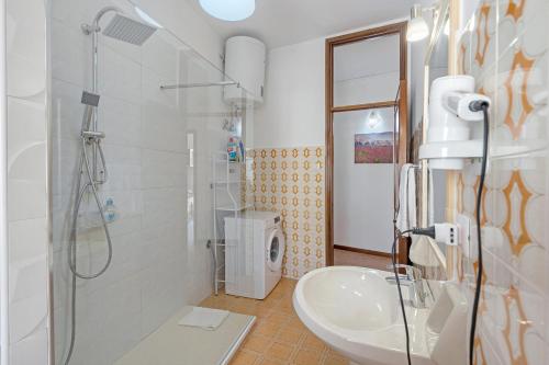 a white bathroom with a shower and a sink at Appartamento il Sentiero degli Dei in Agerola