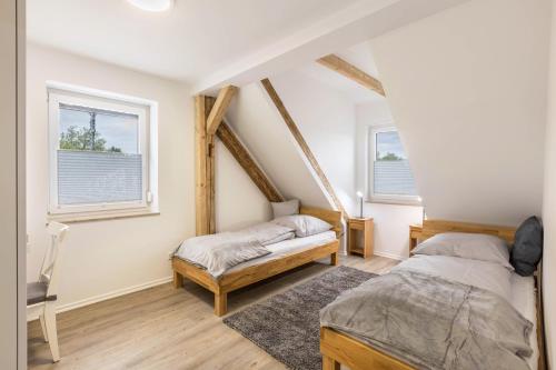 two beds in a room with two windows at Fewo Landblick Geiseltal in Braunsbedra