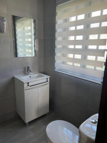 a white bathroom with a sink and a toilet at Quinta da Vigia in Angra do Heroísmo