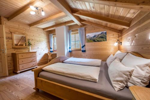 a bedroom with a bed in a log cabin at Ferienhaus Pichlerhof in Fundres