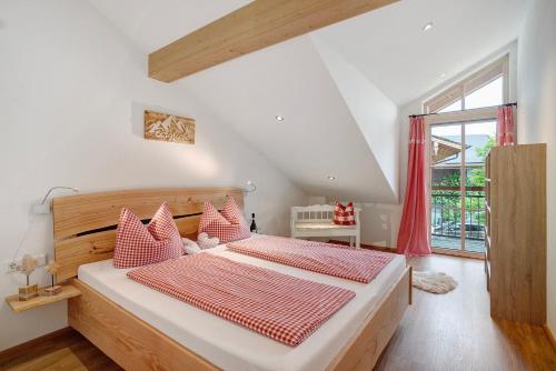 a bedroom with a large bed with red and white pillows at Neubau - Freundliche Fewo Bergblick in Höslwang